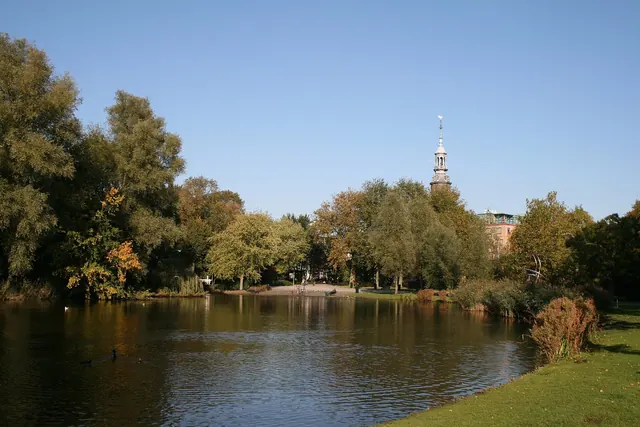 Vijver in het Oosterpark in de herfst, met de toren van de Muiderkerk