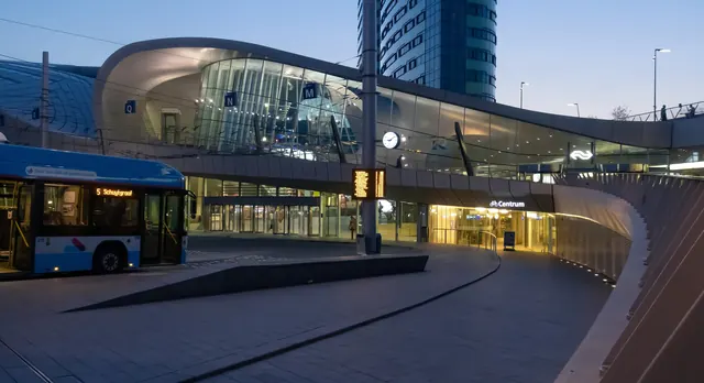 Het plein voor Arnhem Centraal met de stationshal, in de avond