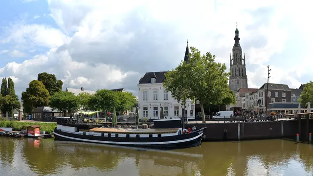 Een boot aan de kade bij het Spanjaardsgat, met de toren van de Grote Kerk erachter (bijgesneden)
