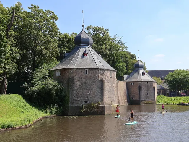 Peddelsurfers op het water voor het Spanjaardsgat, met twee torens van het kasteel