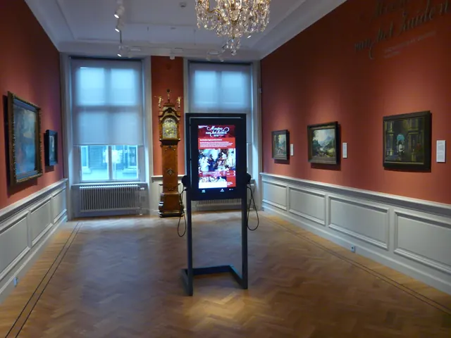 Een zaal in Het Noordbrabants Museum, met schilderijen aan rode wanden en een staande klok