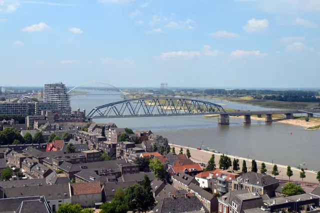 De spoorbrug over de Waal met De Oversteek erachter, gezien vanaf de toren van de Stevenskerk
